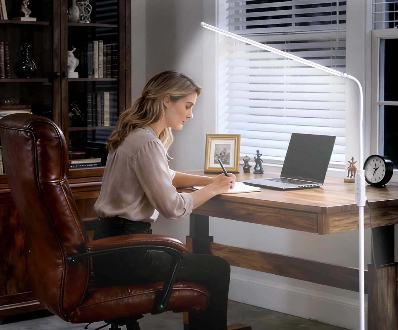 White CGBE gooseneck floor lamp standing beside a chair with its light bar angled down